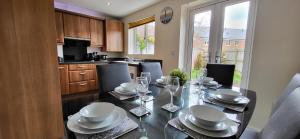 uma cozinha com uma mesa com pratos e copos em The West Wick House em Weston-super-Mare