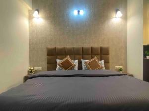 a bedroom with a large bed with two lights above it at Tara Luxury Homes in Solan