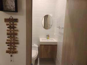 een badkamer met een toilet, een wastafel en een spiegel bij Suite Chipipe AC Wi-Fi Lavanderia a 1 cuadra mar in Salinas