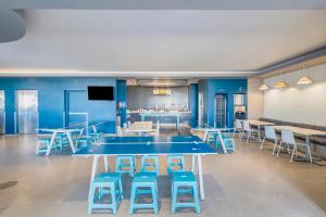 a conference room with a blue table and stools at One Puebla Angelopolis Periferico in Puebla