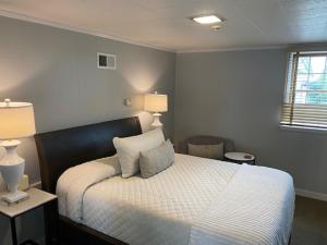 a bedroom with a bed with two lamps and a window at Millsite Lodge in Sandusky