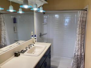 a white bathroom with a sink and a shower at Kula Ohana in Captain Cook