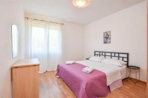 a bedroom with a large bed with a purple blanket at Seaside holiday house Banj, Pasman - 21126 in Ždrelac