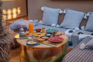 uma mesa com comida e bebidas em cima de um sofá em Little Kasbah em Imsouane