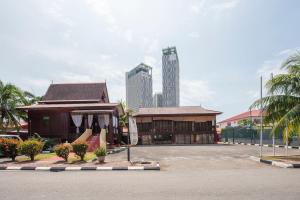 a building in a parking lot with tall buildings at MORTEN VILLA MELAKA in Melaka