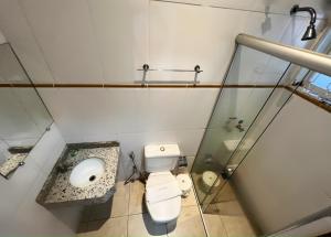 a small bathroom with a toilet and a sink at Hotel Savana in Olímpia