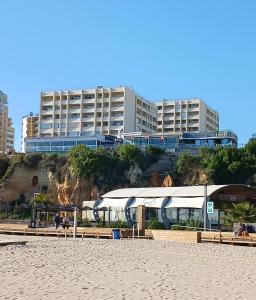 a beach with benches and buildings in the background at Varandas da Rocha in Portimão