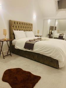 1 dormitorio con 1 cama grande y espejo en Deluxe En suite Bedroom with free on site parking en Milton Keynes