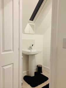 Baño blanco con lavabo y lavabo en Deluxe En suite Bedroom with free on site parking en Milton Keynes