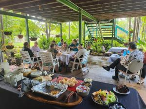 AAOK Lakes Resort and Caravan Park في Berry Springs: مجموعة من الناس يجلسون على طاولة مع الطعام