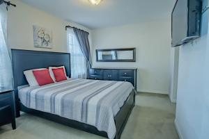 a bedroom with a bed with two red pillows at 5 Bd Villa Home Theater Private Pool Game Room in Davenport +24 photos