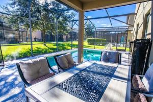 a patio with a table and chairs and a swimming pool at 5 Bd Villa Home Theater Private Pool Game Room in Davenport