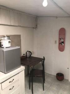 a small kitchen with a table and a skateboard on the wall at Casa Ausa - Bacnotan La Union in Bacnotan