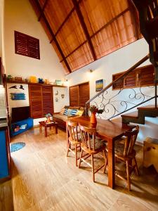 een woonkamer met een houten tafel en een trap bij Vila Feliz - Chalés completos - ideal para famílias in Serra de São Bento