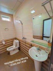 een badkamer met een toilet, een wastafel en een douche bij Nhà Nghỉ Hồng Nhung in Mai Chau