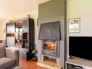 sala de estar con chimenea y TV de pantalla plana en Holiday home ideal for families, en Bièvre