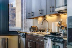 a kitchen with a sink and a counter top at Luxe City Views in DT Pittsburgh VALET GYM WIFI in Pittsburgh