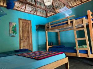 1 dormitorio con 2 literas y pared azul en Sunrise El Paredón, en El Paredón Buena Vista
