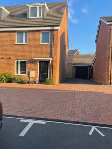 a brick house with a brick driveway in front of it at Deluxe En suite Bedroom with free on site parking in Milton Keynes