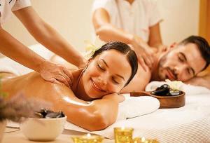 a man and woman getting a massage in a bed at FULL SPA ISLA NEGRA Suites in Isla Negra