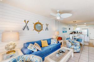 Una sala de estar con un sofá azul y una mesa. en Buena Vista 405, en Gulf Shores