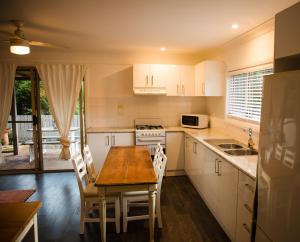 a kitchen with white cabinets and a wooden table at Forgotten Valley Guesthouse in Gunderman