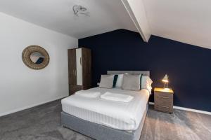 een slaapkamer met een bed met een blauwe accentmuur bij Free Parking Spacious Leisure Near National Park in Lackenby
