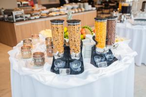 une table avec quatre grands vases remplis de nourriture dans l'établissement Dall'Onder Planalto Hotel Bento Gonçalves, à Bento Gonçalves