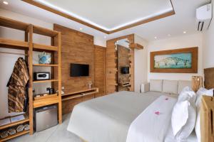 una camera da letto con un grande letto bianco e pareti in legno di Ponte Villas a Gili Trawangan