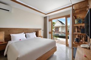 a bedroom with a bed and a sliding glass door at Ponte Villas in Gili Trawangan