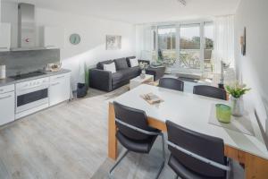 cocina y sala de estar con mesa y sillas en Meerliebe en Norderney