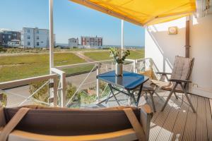 a balcony with a table and chairs and a view at Meerliebe in Norderney