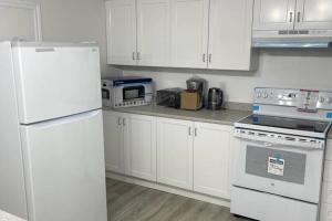 una cocina con electrodomésticos blancos y armarios blancos en Central, convenient and comfortable 3 Bedrooms house near downtown Gatineau/Ottawa with free parking en Gatineau