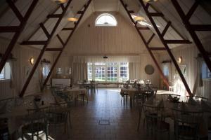 a dining room with tables and chairs in a building at Wallby Säteri Gårdshotell & Konferens in Skirö