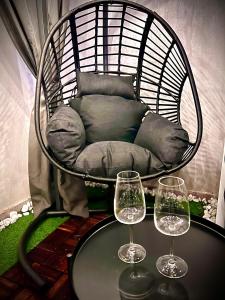 a chair with two wine glasses on a table at NapoliOn - Luxury Apartment in Naples