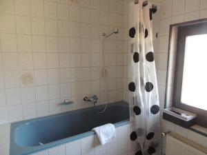 een badkamer met een douche en een blauw bad bij Hotel de la Gare in Cousset 