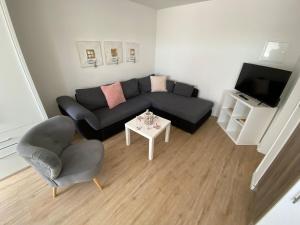 uma sala de estar com um sofá e uma mesa em Hafenloft App 4 em Norderney