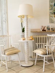 une table avec une lampe de sol blanche à côté de deux chaises dans l'établissement Hostal Marina Cadaqués, à Cadaqués