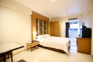 une chambre d'hôtel avec un lit et une télévision dans l'établissement Synsiri Lat Phrao 83, à Ban Zong Katiam