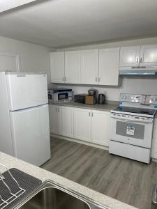 una cocina con electrodomésticos blancos y armarios blancos en Central, convenient and comfortable 3 Bedrooms house near downtown Gatineau/Ottawa with free parking en Gatineau