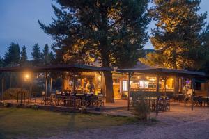 a restaurant with tables and chairs at night at Complejo Playa Bonita in San Martín de los Andes