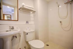 La salle de bains blanche est pourvue de toilettes et d'un lavabo. dans l'établissement Synsiri Lat Phrao 83, à Ban Zong Katiam