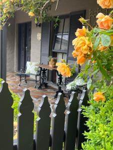 a fence in front of a house with orange flowers at Gracehill Accommodation in Olinda