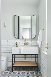 La salle de bains est pourvue d'un lavabo et d'un miroir. dans l'établissement Portarlington Grand Hotel, à Portarlington