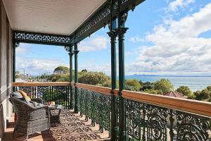 a balcony with a table and chairs and the ocean at Portarlington Grand Hotel in Portarlington