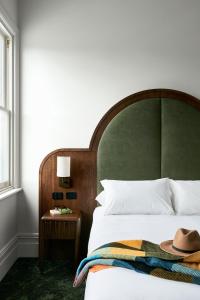 波塔靈頓的住宿－Portarlington Grand Hotel，一间卧室,配有一张床,上面有帽子