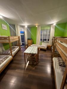 a room with several bunk beds and a table at Hostel 1902 in Zakopane