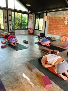 um grupo de pessoas a fazer yoga numa sala em Aonang Third Place Hometel em Praia de Aonang