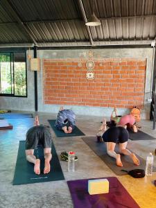 un grupo de personas en una clase de yoga en Aonang Third Place Hometel, en Ao Nang Beach