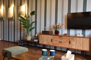 un salon avec une télévision sur un meuble en bois dans l'établissement South Island 206, à Hengchun Old Town